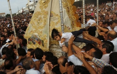 Pilgrims carry a girl to touch the Virgin of El Rocio during a procession around the shrine of El Rocio in Almonte, southern Spain