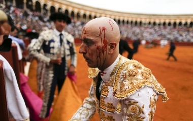 Spanish matador Javier Castano is seen with his face splattered by bull's blood after killing it during a bullfight in Seville, southern Spain