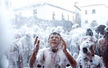 A reveller covered in paint washes his face as he take part in the annual "Cascamorras" festival in Guadix