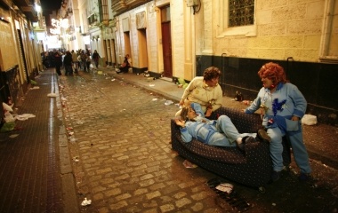 Women dressed up chat on a street during the Carnival in Cadiz