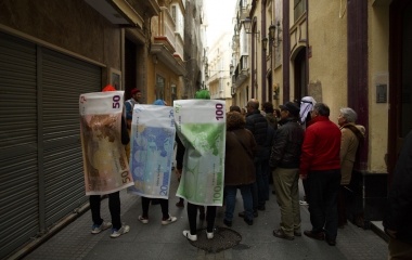 Revelers dressed as Euro banknotes stand on a street during the Carnival of Cadiz