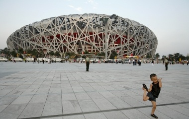 A boy play in front of the National Stadium, also known as the Bird's Nest before starting the last rehearsal of the opening ceremony in at the Beijing 2008 Olympic Games