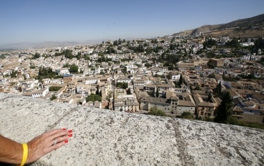 A woman looks the city of Granada from the Alcazaba (Citadel) in the Alhambra in Granada