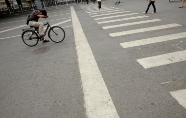 A man waits to rides in front of a zebra crossing in Beijing ahead of the Beijing 2008 Olympic Games