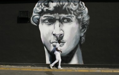 A man walks past a painted mural of an interior decorating shop in Tomares