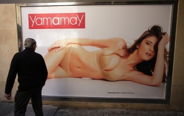 A man looks at a poster of a lingerie shop in central Andalusian capital of Seville