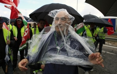 An Iberia employee puts a rain cover as he takes part in a protest march near Seville's San Pablo airport during an Iberia strike