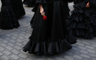 A model wearing a flamenca dress holds a red rose as she takes part in an event to mark the twentieth anniversary of the International Flamenco Fashion Show SIMOF in Seville