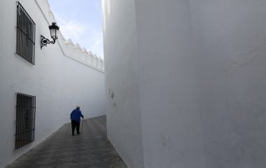 An elderly woman walks aided by a cane during the International Day of older persons in Tomares, near Seville