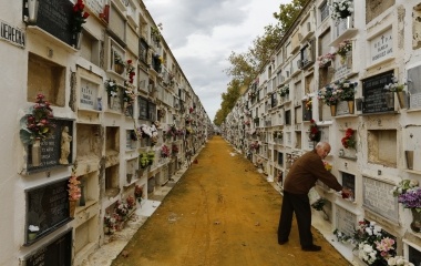 A man visits a grave during All Saints Day at the cemetery of San Fernando in the Andalusian capital of Seville
