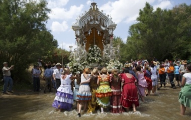 Pilgrims push a carriage as they cross Quema river on their way to the shrine of El Rocio in Aznalcazar, southern Spain