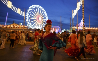 A woman wearing a sevillana dress looks back during the traditional Feria de Abril (April fair) in the Andalusian capital of Seville