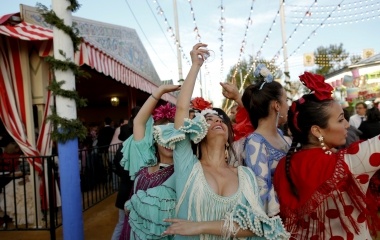 Women wearing sevillana dresses dance during the traditional Feria de Abril (April fair) in the Andalusian capital of Seville