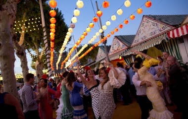 Women wearing Sevillana dresses dance during the traditional Feria de Abril (April fair) in the Andalusian capital of Seville
