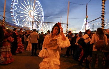 A woman wearing a sevillana dress walks during the traditional Feria de Abril (April fair) in the Andalusian capital of Seville