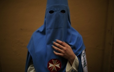 Macarena, a penitent woman of "San Esteban" brotherhood poses for a portrait before making their penance during Holy Week in the Andalusian capital of Seville