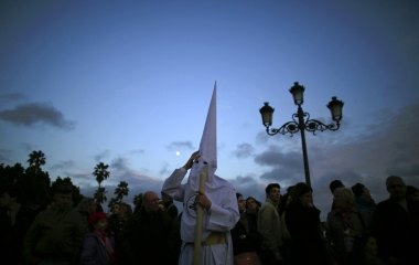 A penitent of "San Gonzalo" brotherhood makes his penance during Holy Week in the Andalusian capital of Seville