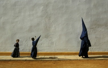 PENITENTS WALK TO THE CHURCH TO START A HOLY WEEK PROCESSION IN SEVILLE