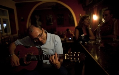 Jose Manuel Abel, 46, plays a guitar in the restaurant where he works after finishing his first working day as a kitchen assistant in Munich