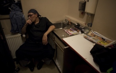 Jose Manuel Abel, 46, smokes a cigarette during a break time of his second working day as a kitchen assistant in Munich