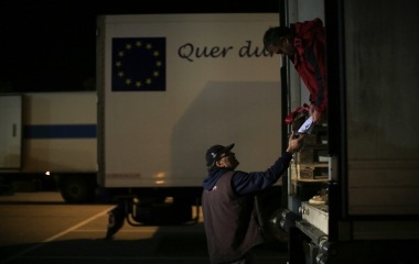 Jose Manuel Abel, 47, takes a delivery note from a lorry driver after picking a ware up during his work day in Munich