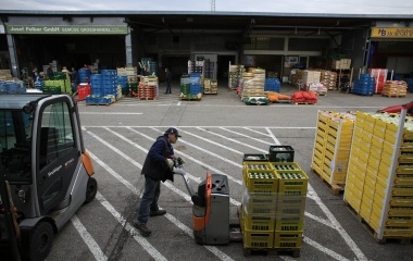 Jose Manuel Abel, 47, takes a pale during his work day at a fruit and vegetable storage warehouse in Munich