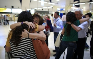 Spanish nurses Maria Teresa Marin embraces her mother Nati, as her twin sister Maria Jose, embraces her father Jose Manuel, at San Pablo airport in Seville, southern Spain