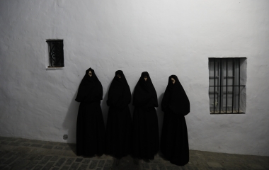 Women wearing "Cobijada" outfits pose for a portrait in Vejer de la Frontera, southern Spain