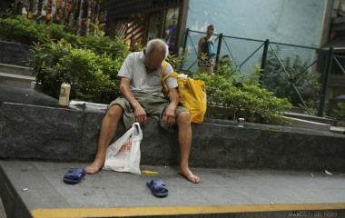 A man sleeps as he sits under the Central-Mid-Level Escalators in the Central district in Hong Kong