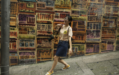 A young woman laughs as she poses for pictures in the Soho district in Hong Kong