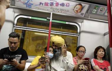 People sit in a wagon of a Island line subway in Hong Kong