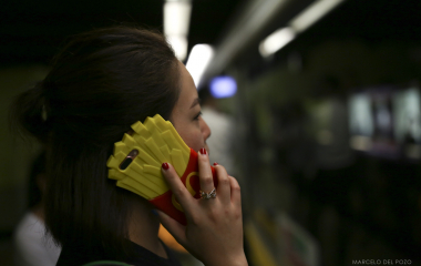 A woman holds a mobile phone in a Island line station in Hong Kong