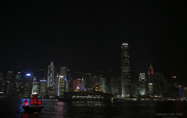 A cruise ship sails past the skyline of the Hong Kong city