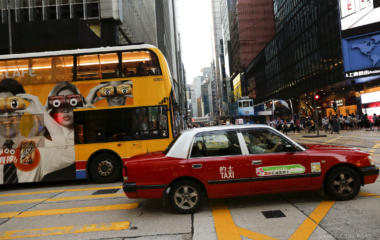 A taxi and a bus cross the main crossing in Central district in Hong Kong
