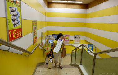 A woman carries her grocery shopping as she leaves a supermarket in the Mong Kok district in Hong Kong