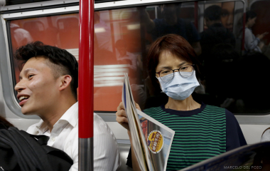 People sit in a wagon of the Island line subway in Hong Kong