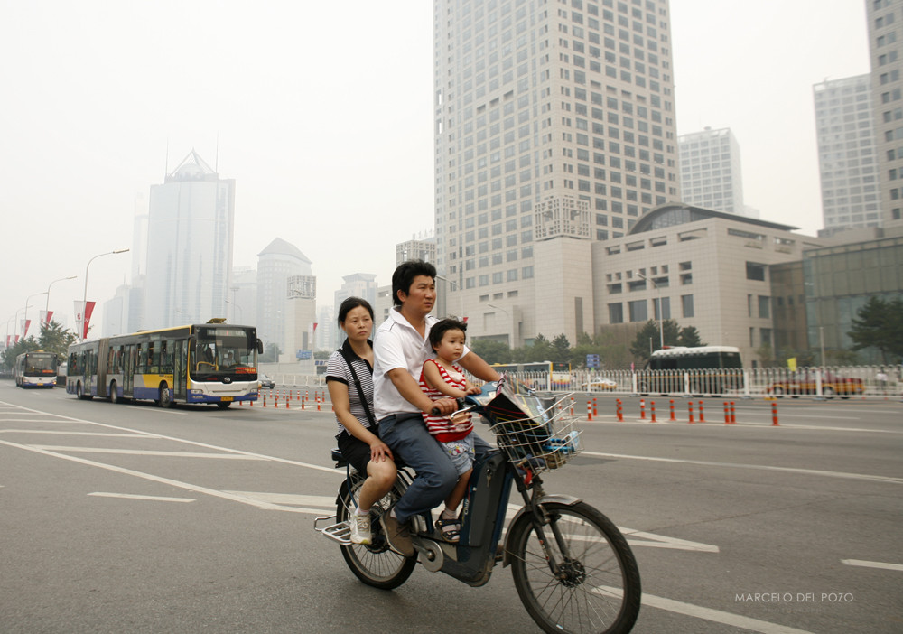People ride a moped in Beijing