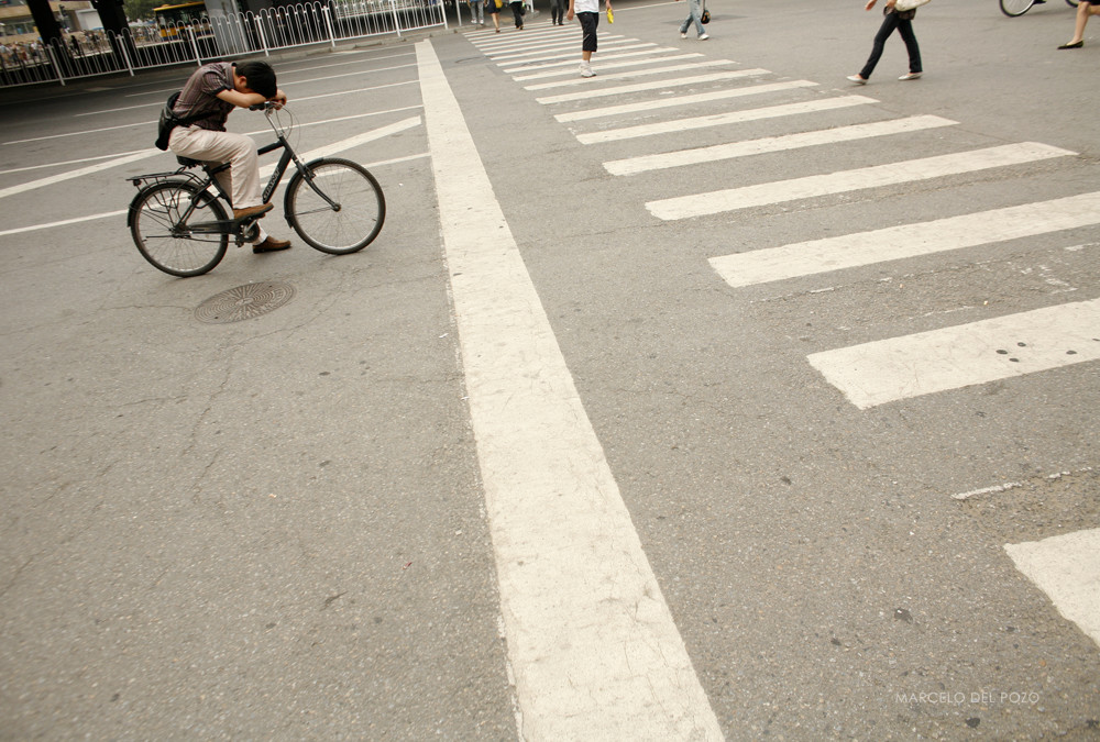 A cyclist waits for pedestrians to cross a zebra crossing in Beijing