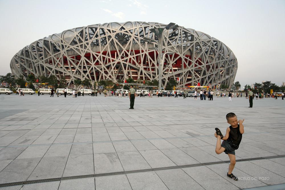 A boy plays in front of the National Stadium before the last rehearsal for the opening ceremony of the Beijing 2008 Olympic Games