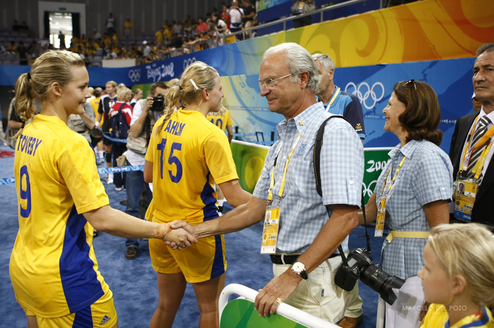 Sweden's King Carl Gustaf and Queen Silvia shake hands with Sweden players at the end of the women's quarter-final handball match between Norway and Sweden at the Beijing 2008 Olympics Games