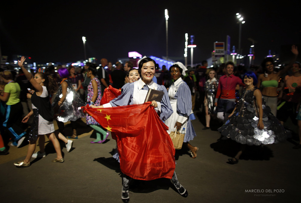 A performer holding a China flag laughs after participating in the opening ceremony of the London 2012 Olympic Games next to the Olympic Stadium at the Olympic Park in London