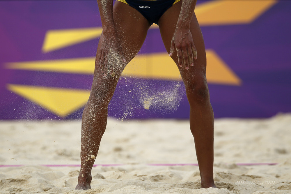 Brazil's Juliana Silva dusts off sand from her legs during their women's preliminary round beach volleyball match against Czech Republic's Hana Klapalova and Lenka Hajeckova at Horse Guards Parade during the London 2012 Olympic Games