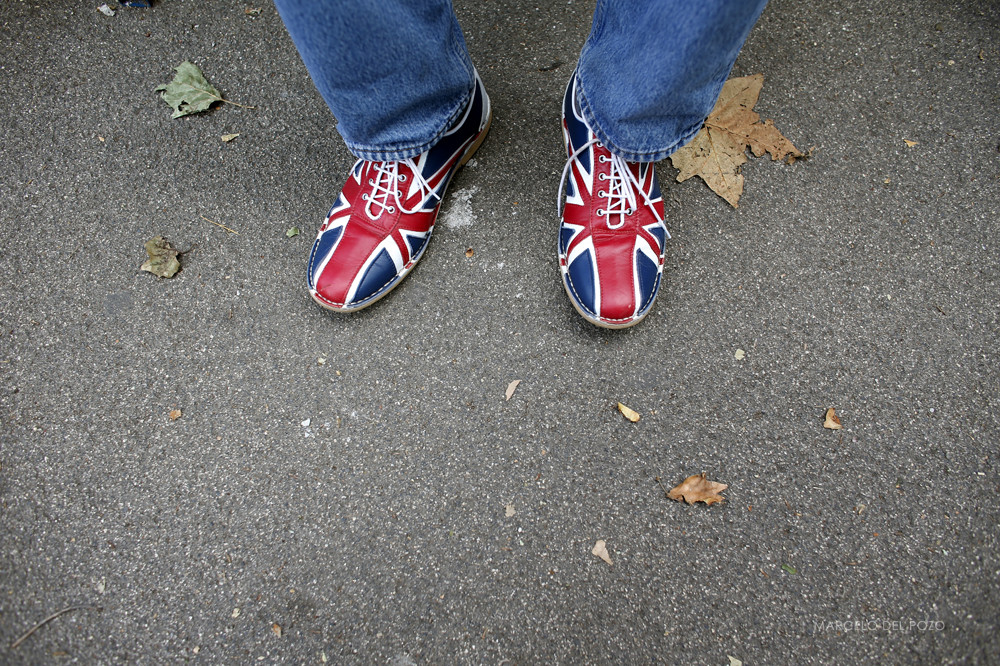 A man wearing shoes bearing the Union Flag, commonly known as the Union Jack, sits outside Horse Guards Parade during the London 2012 Olympic Games
